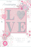 Designed with the soft romance of an English spring evening in Hatton, this anniversary card offers a gentle celebration of enduring love. The central feature is the word LOVE, spelled out in raised, velvety letters dusted with fine blush and silver glitter. The tactile glitter catches the light in subtle glints, echoing the shimmer of headlights tracing the perimeter roads near Heathrow while remaining soothing and intimate rather than bright. The letter O subtly forms a rounded heart shape, enriched with a touch more silver, making the centre feel especially tender and symbolic. Encircling this focal word, delicate blossoms in shades of blush pink and muted mauve appear to unfurl softly across the card, their edges diffused as though painted with a wet brush. Slender stems, trailing vines, and fluid swirl motifs weave around the flowers, suggesting graceful motion, like a bouquet swaying gently in a vase placed by a window overlooking Hatton's quiet streets. Tiny, almost secret butterflies and petals are scattered within the composition, adding lightness and playfulness. The background stays in a hushed pastel pink with gentle grey undertones, keeping the overall look refined and calm. Silver highlights glimmer along some petals and curves, enriching the design without crowding it. In a graceful, flowing script, sentiments such as On Our Anniversary and I love you today and always are written with a sincerity that feels personal, as if penned by hand. The card as a whole conveys a sense of occasion and shared journey-soft-spoken yet profoundly heartfelt, like a favourite anniversary bouquet delivered by Flower Delivery Hatton to mark another cherished year together.